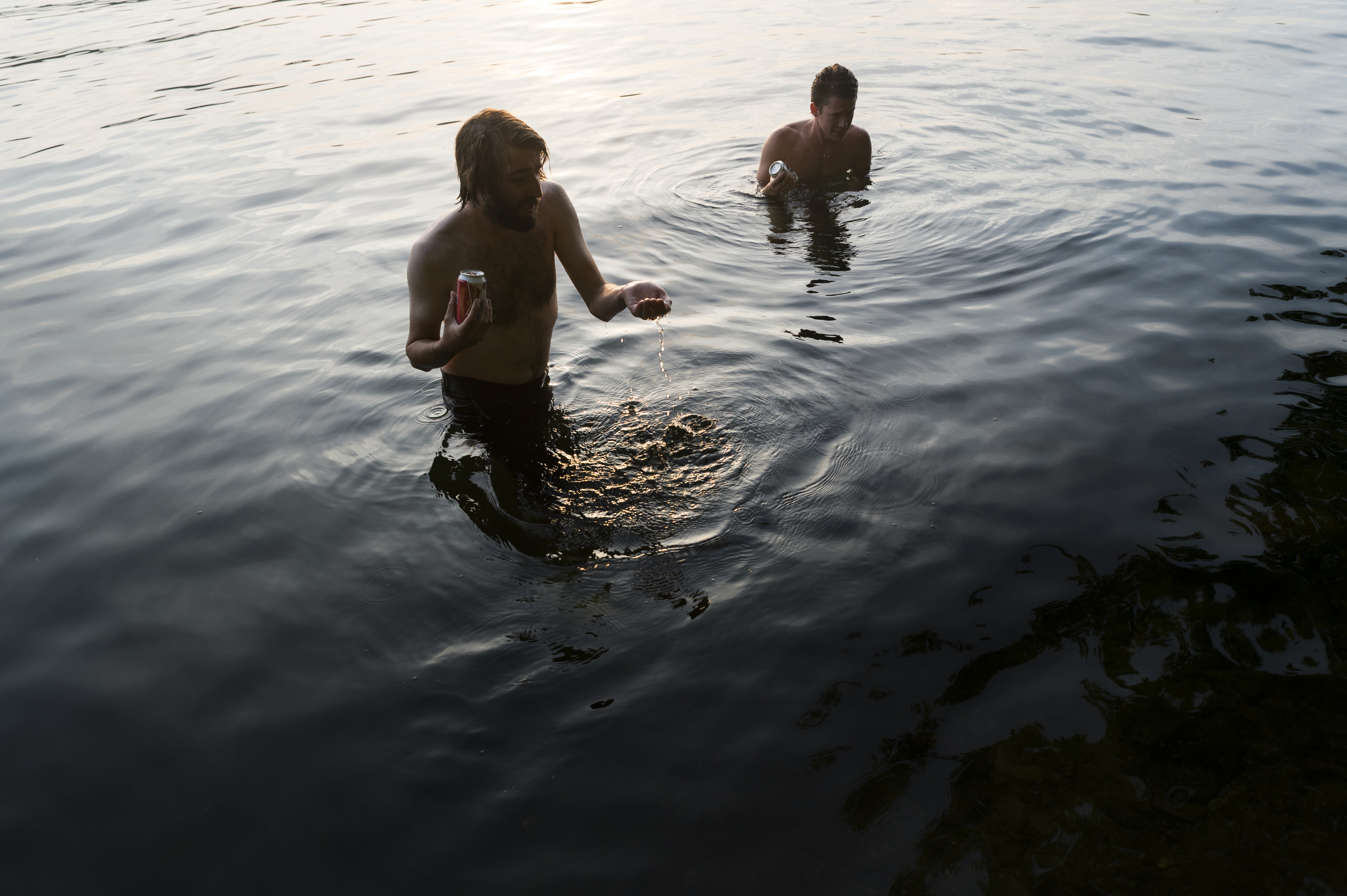 Adam Ruster (left) and Mark Vanatta (right) wade in the shallows of Lake Burden near Albany NY. Jul 27, 2014 After hours spent unsuccessfully trying to drain an abandoned pool, the group of skaters resorted to swimming in the lake and exploring the area rather than skating.