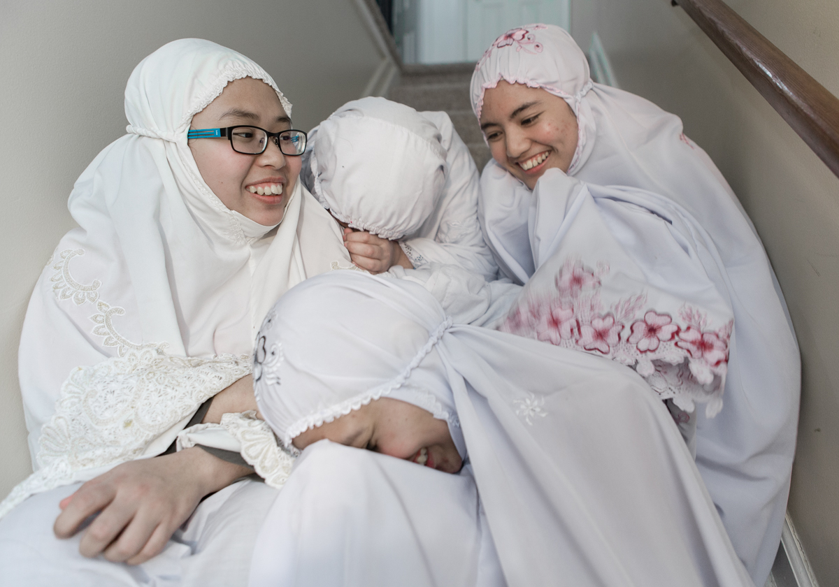 After the night prayer, Aiman, Nadia, Norazleen and Fatini sit together on their staircase at their apartment in Rochester NY. Dec 10, 2014.