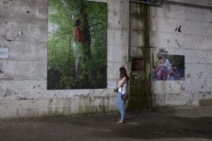 Brittainy Newman looks at a photo exhibit at the Srebrenica Memorial in Srebrenica, Serbia on July 23, 2016. The memorial commemorates the 1995 genocide of over 8,000 Muslim Bosniaks by the Serbian Army. The photo of the suicide of Ferida Osmanovic on the wall is by Darko Bandic.