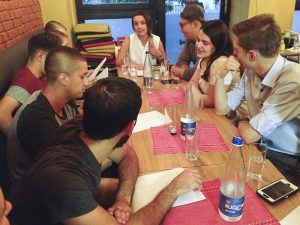 Alketa Bucaj (center) teaches Wentian Chen (center right) and other students basic Albanian phrases at an Italian restaurant in Prishtina.