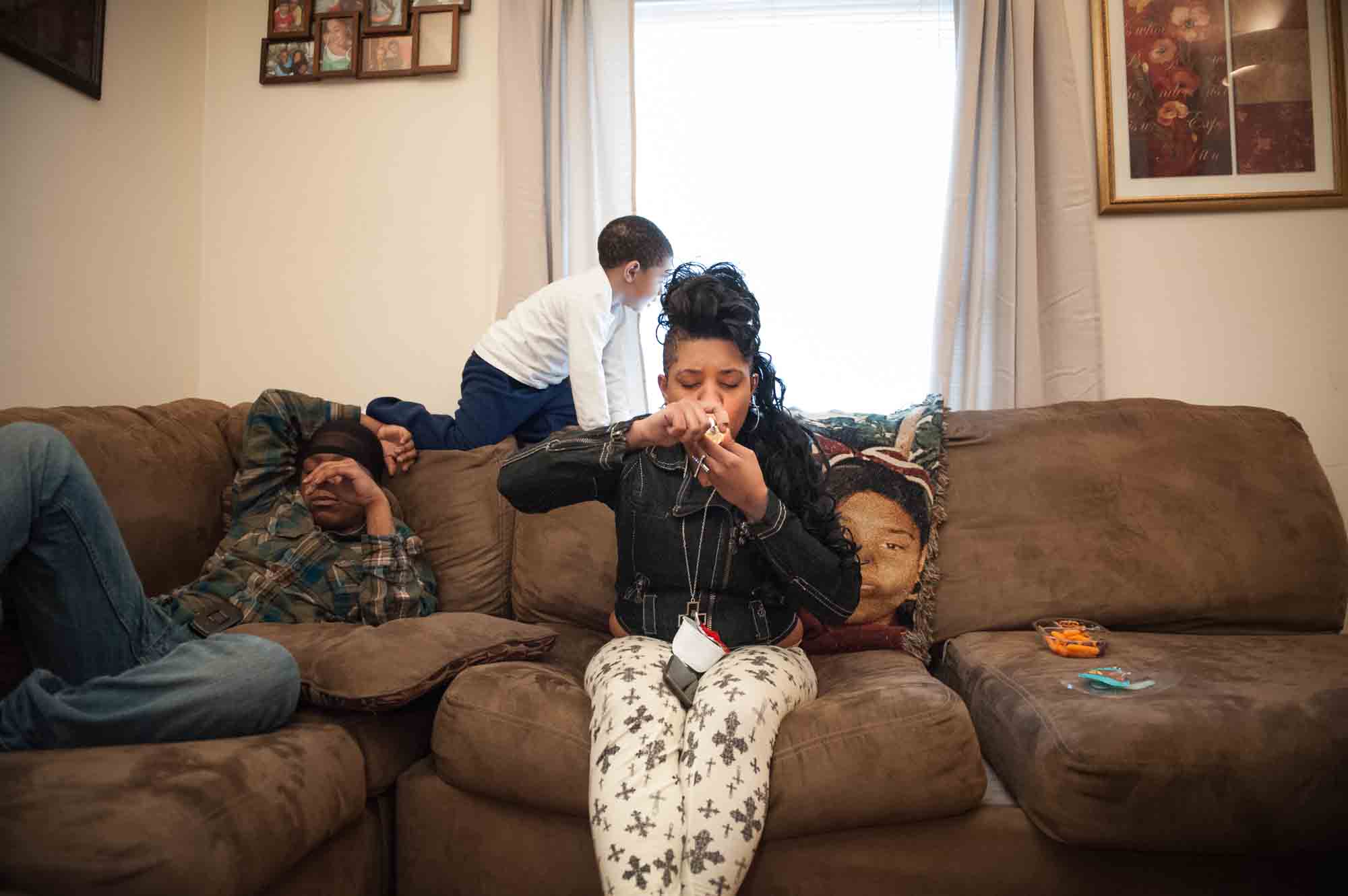 Single mother Erica, 22, smokes marijuana with a friend while her 3-year-old son plays in their living room April 11, 2013.