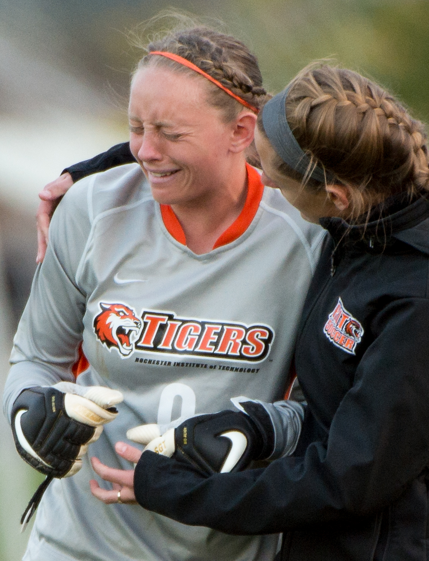 Rochester Institute of Technology goalkeeper Amanda Murray, left, is comforted by goalkeeper coach Katie Dry, right, after a 2-1 loss to Skidmore on Friday, Oct. 18, 2013 at Tiger Stadium  in Henrietta, N.Y. Skidmore scored in the last minute of regulation to win a key conference game. Photo by Josh Barber