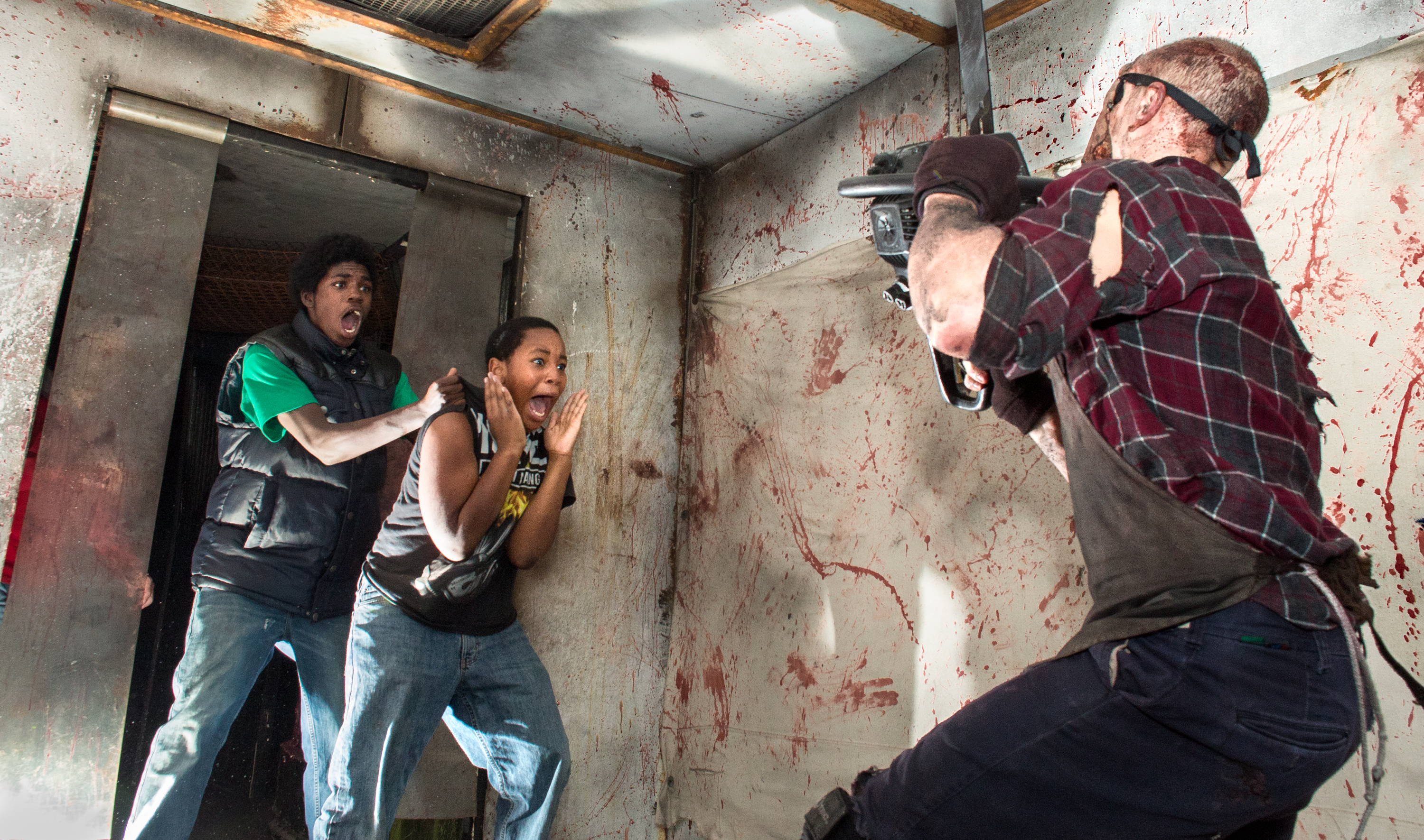 Jason Skuse of Cheektowaga, NY chases Alex Greene and Latoya Smith of Buffalo, NY through the "Grindhouse" with a chainsaw at FrightWorld ScreamPark on Oct. 30, 2013 in Tonawanda, NY. FrightWorld ScreamPark has been providing thrills to the Buffalo area for 11 years. Skuse, an actor at Frightworld, says, "We try to bring something new and scarier every year. The Grindhouse has been a hit for sure. I actually wish this was a year-round job. It's a lot of fun." Photo by Zack DeClerck