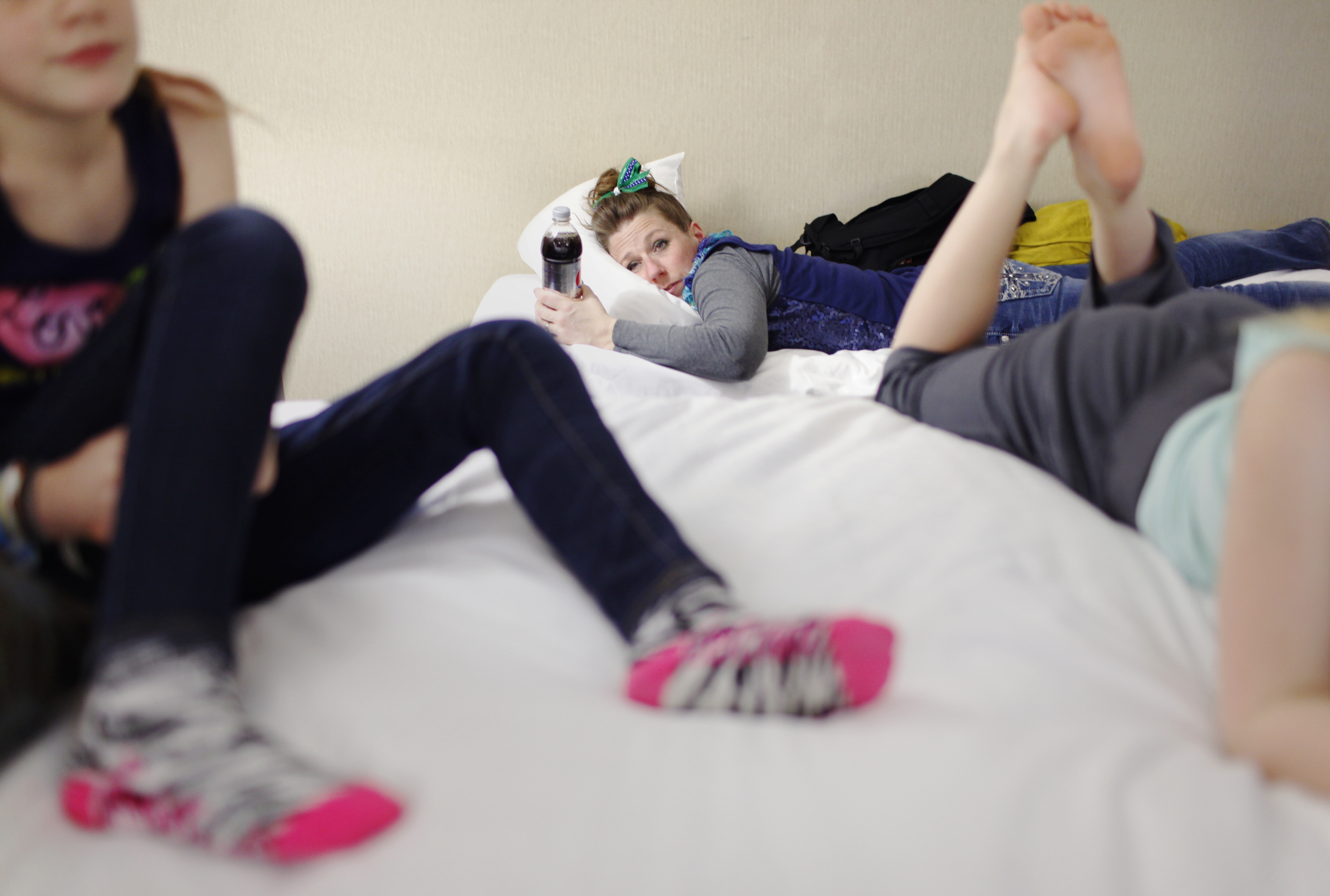 Jennifer Holfeltz, 40, rests following a 13-hour day of varsity cheerleading in Buffalo, NY, on March 1, 2014. Three of her daughters cheer competitively. "They eat, breathe, and sleep this," she commented. Photo by Niki Walker