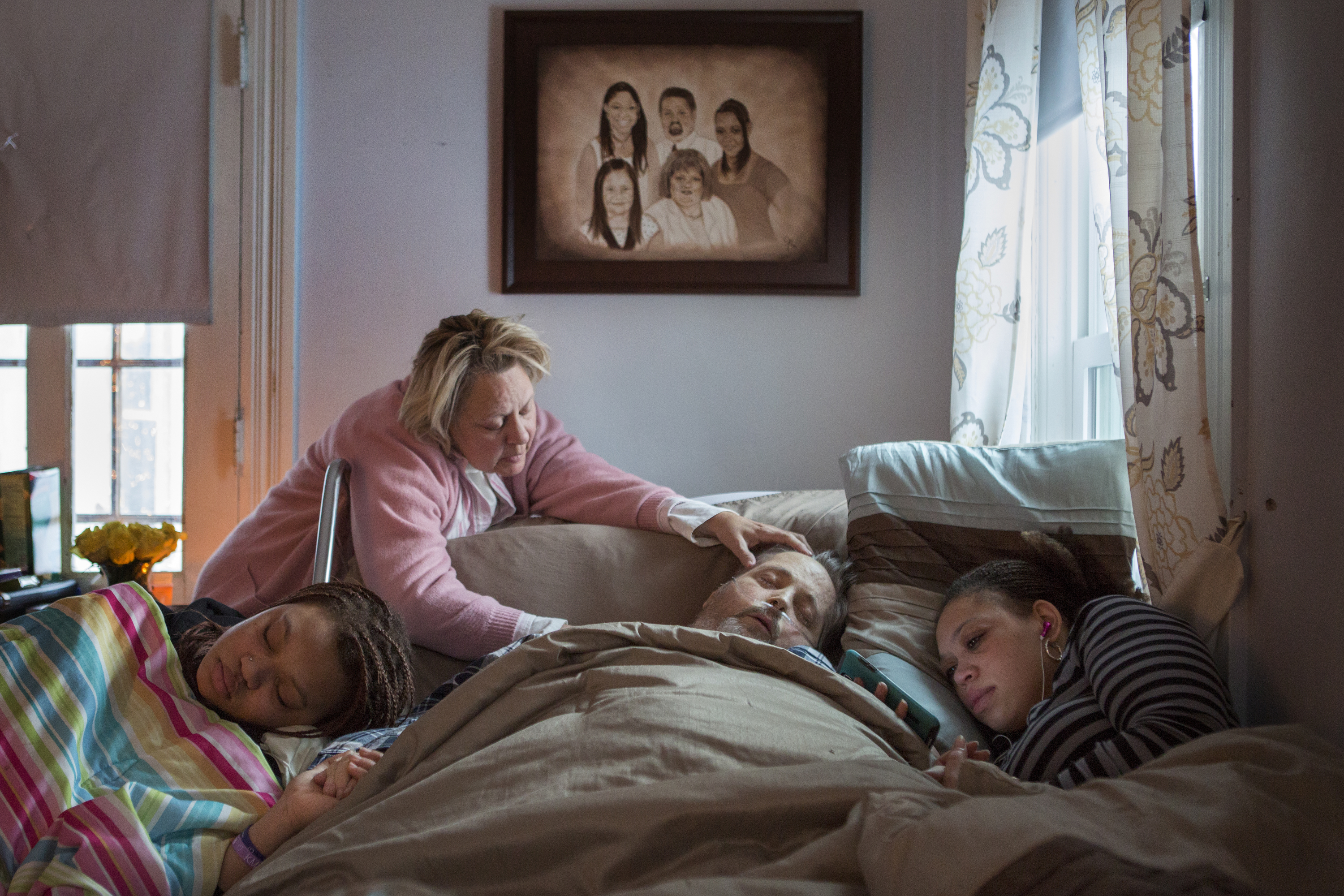 Dan Nagele, center, lays in bed while on hospice care, as adopted daughter Kyra Nagele, left, Yvonne Guest, middle, and daughter Shanna Cunningham, right, console Dan during his final hours shortly before passing away on Monday, February 16, 2015 in Avon, N.Y.  Dan's wife, Loretta passed away in 2009 to cancer, leaving Kyra and Shanna orphaned.  Dan suffered from Nonalcoholic Steatohepatitis disease, (NASH) which is a fatal liver disease that resembles alcohol liver disease, but occurs in people who drink little or no alcohol.