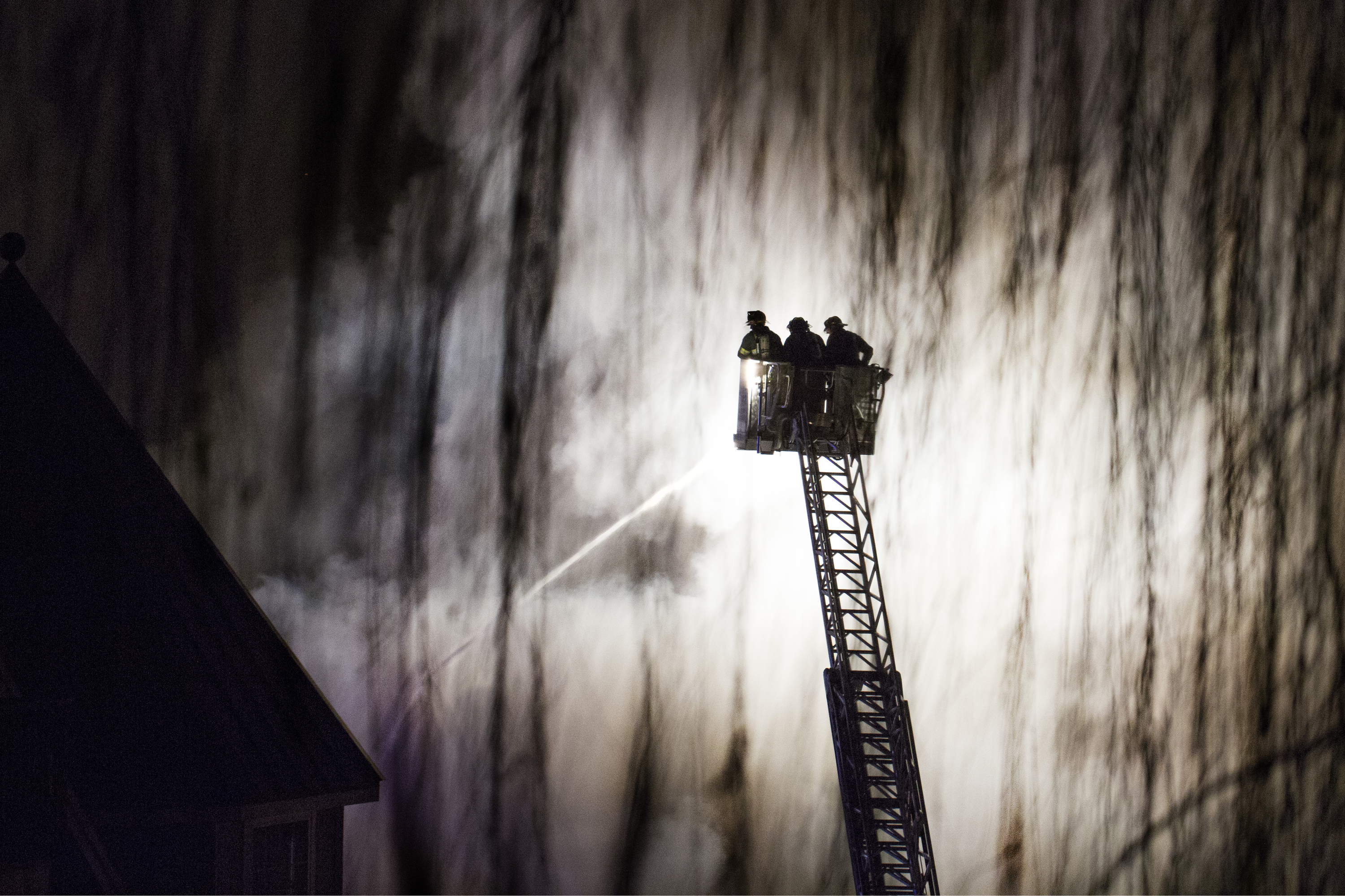 Firefighters of the Ramsey fire department project water onto the Avalon apartment complex during a 5-alarm fire on Tuesday, Jan. 21, 2015 in Edgewater, N.J.  The fire, which displaced some 1,000 people was caused by a plumbing repair that ignited a fire in the wall which then spread through the building.  No fatalities were reported.