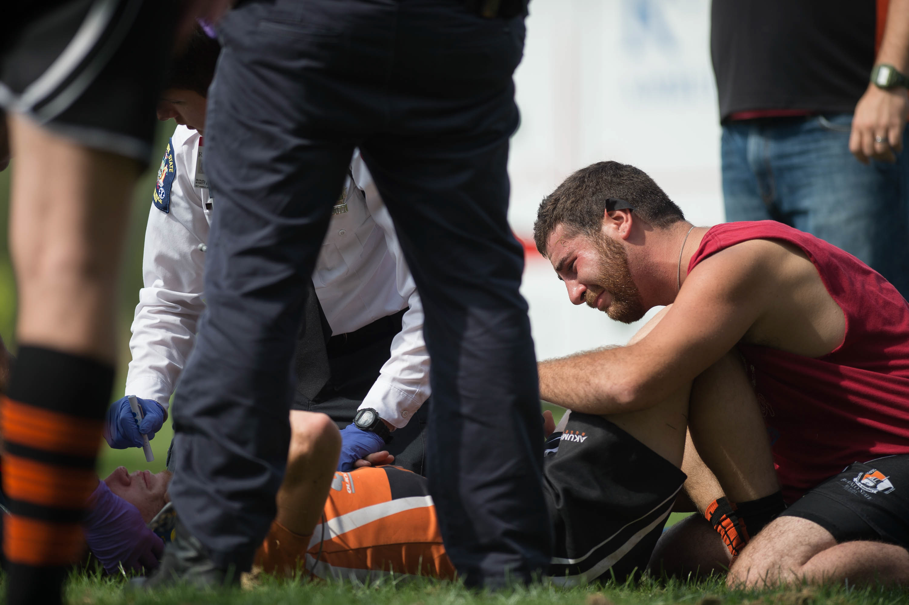 Close friend Anthony Adams, right, looks on as Thomas L. McNulty, RIT ambulance, checks the vitals of Christian Feickert after a brutal hit on the Rugby Field on the Rochester Institute of Technology campus in West Henrietta, N.Y. on Sept. 26, 2015. Christian later found out at the hospital that he had a severe concussion.