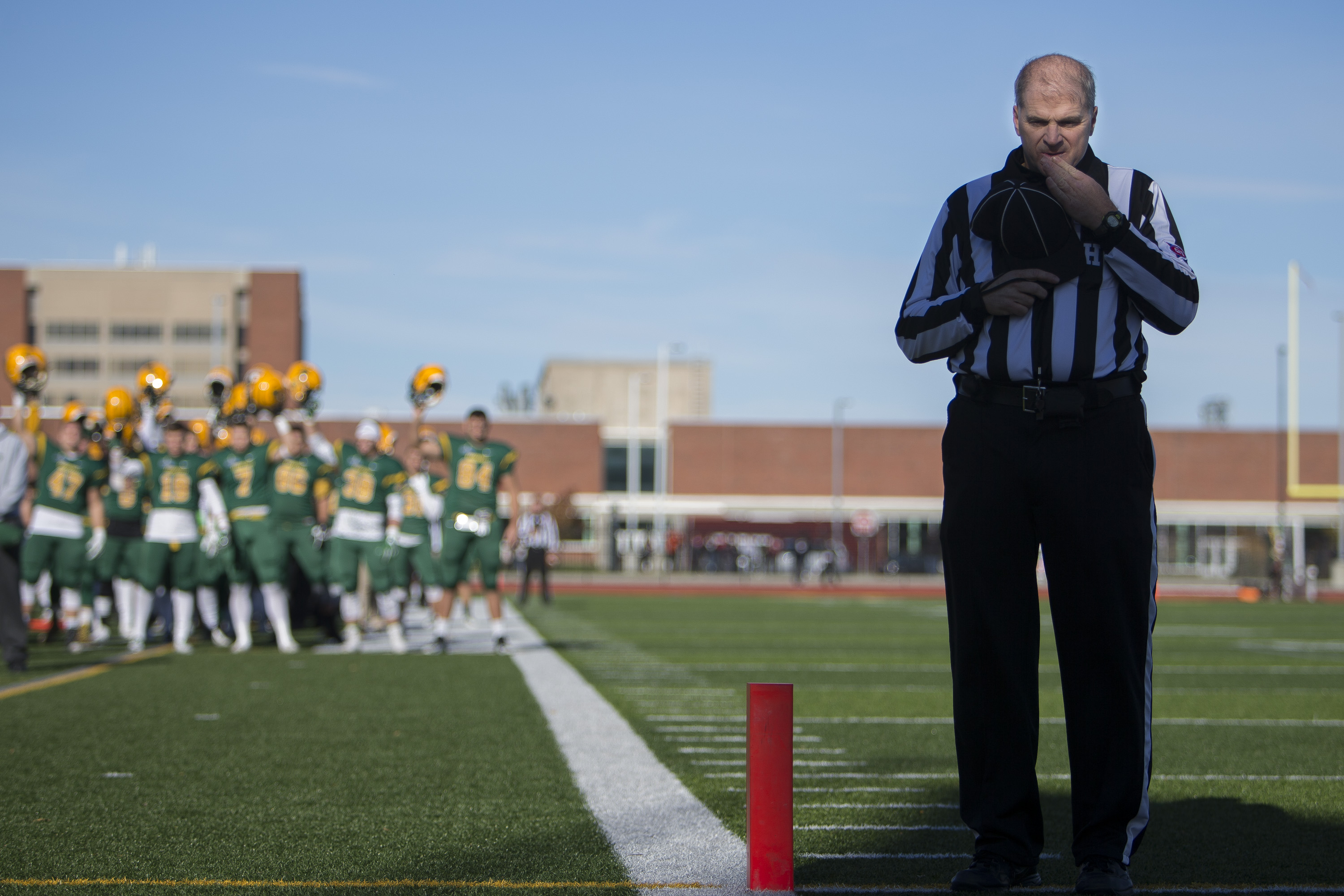 Referee Steve Campbell stands in the end zone for the National Anthem at the Bob Boozer Field on the college of Brockport campus in Brockport, N.Y. on Nov. 12, 2016.
